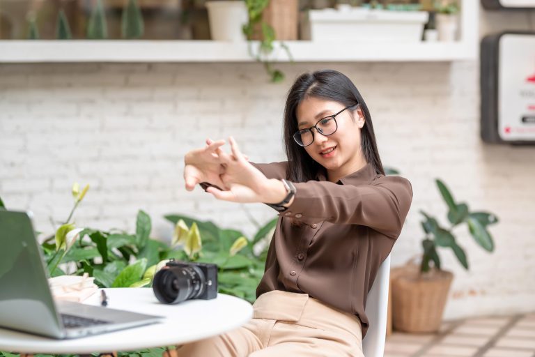 Asian businesswoman in glasses working at a cafe relaxing to stretch your arms. working concept